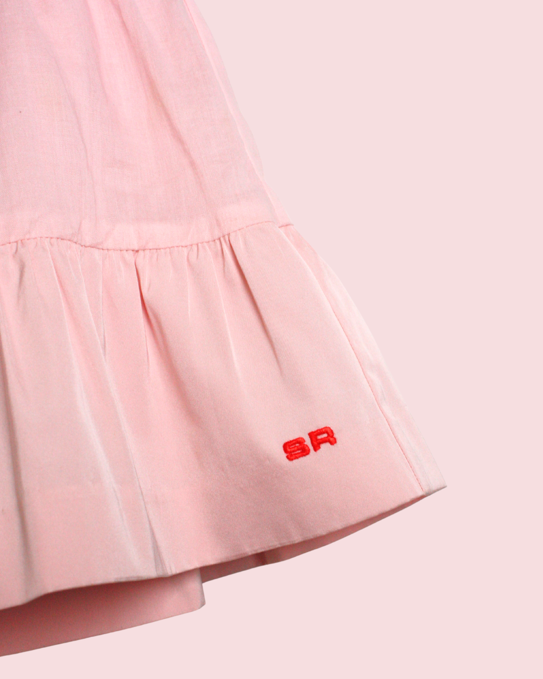 Jupe courte rose à volant et signature 4 ans