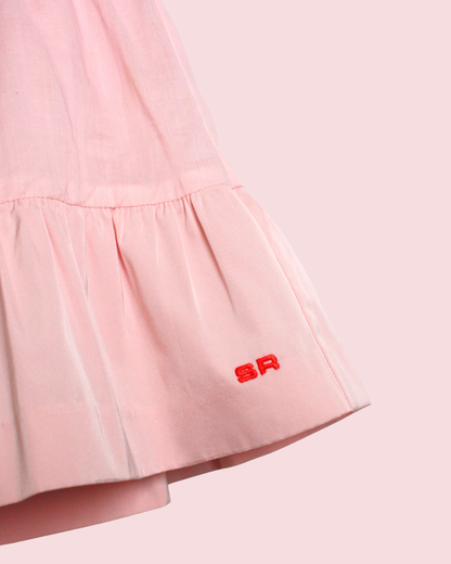 Jupe courte rose à volant et signature 4 ans